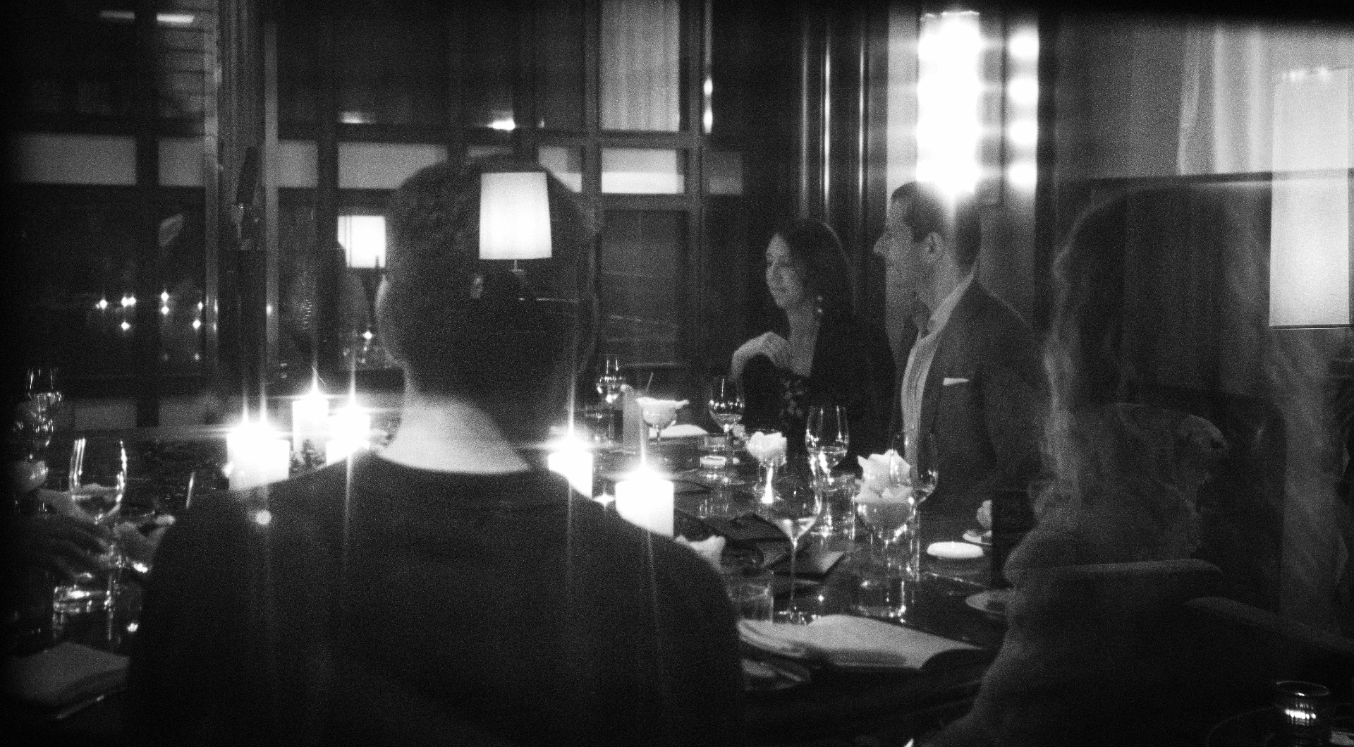 Black-and-white photograph of an intimate Cureators dinner by candlelight